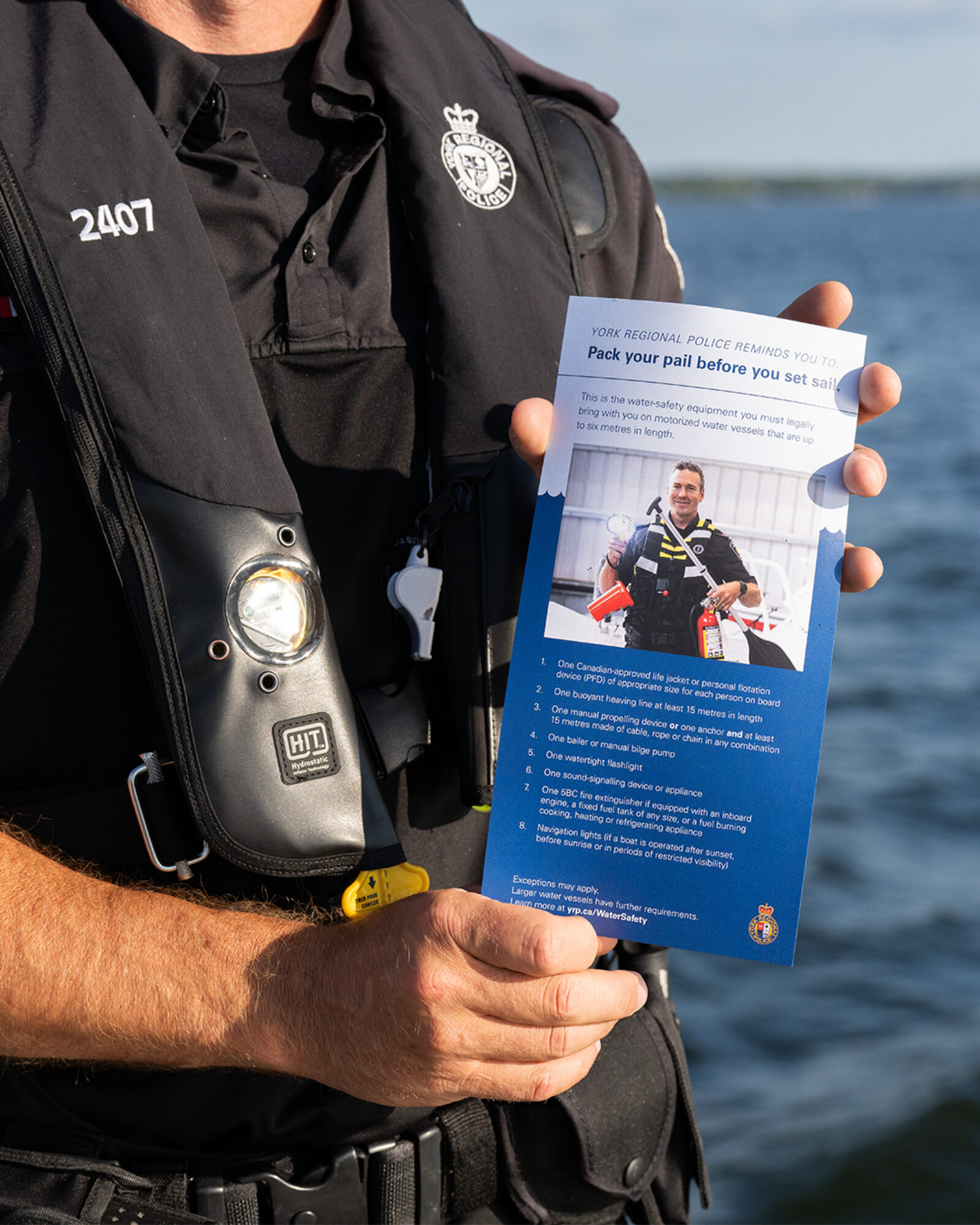 York Regional Police Marine Unit officer displaying a handout on water safety requirements for motorized vessels under six meters.